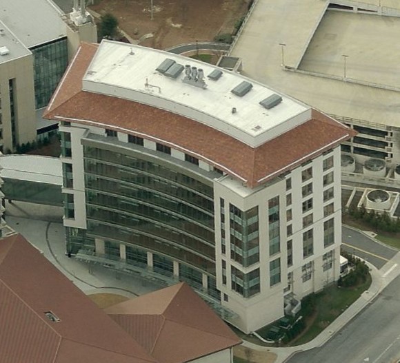 Aerial view of a curved, multi-story office building with a red-tiled roof.