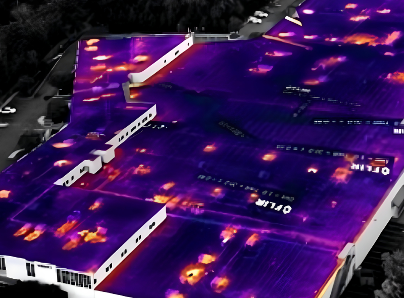 Thermal aerial view of a building roof, showing heat loss in orange and yellow against a cool purple background.