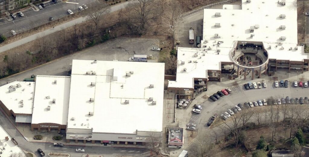 An aerial view of a shopping center featuring a Trader Joes and a Tuesday Morning store surrounded by parking lots.